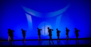 Danza sobre escenario con fondo azul